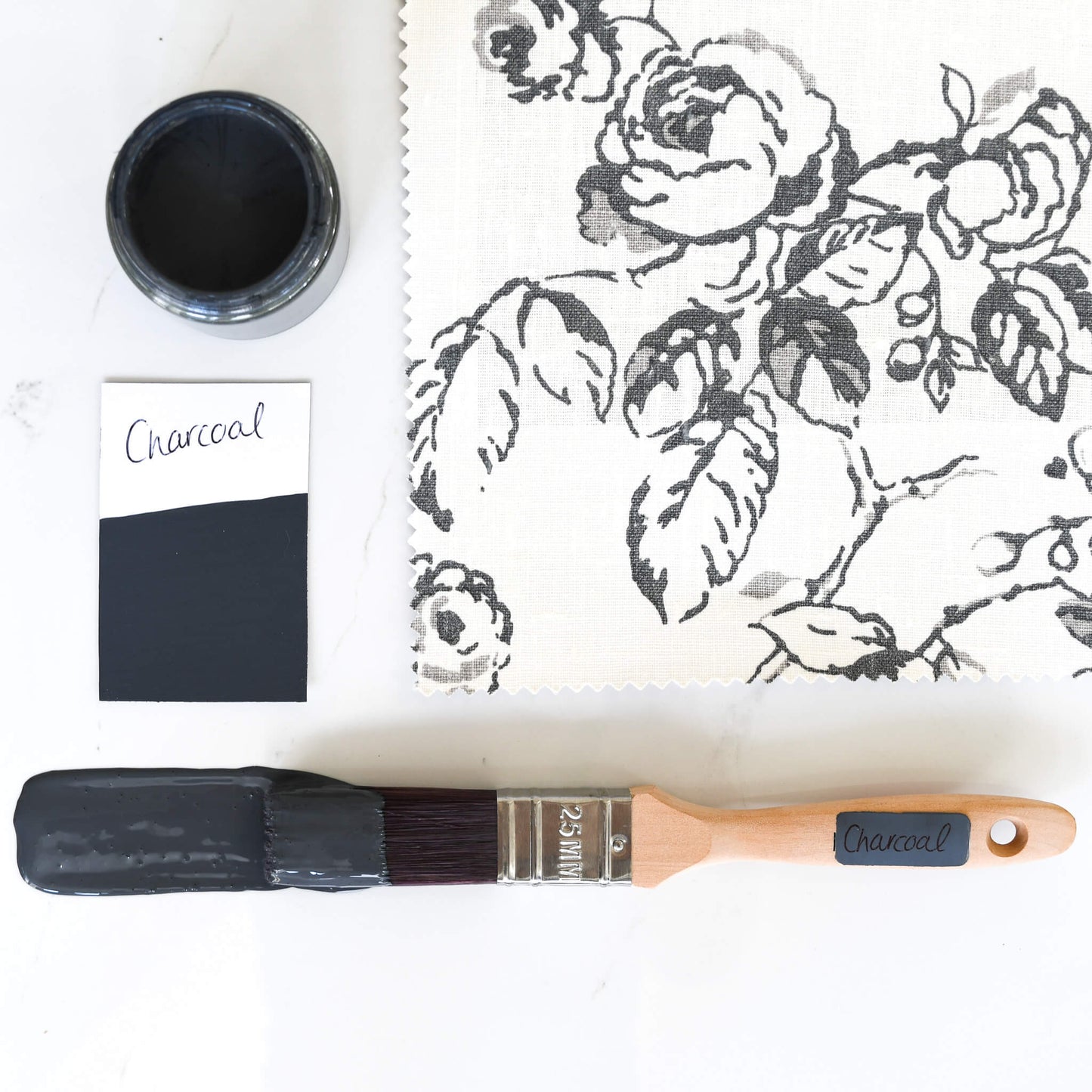 paint brush dipped in 120ml pot of Charcoal Blake & Taylor Chalk Furniture Paint