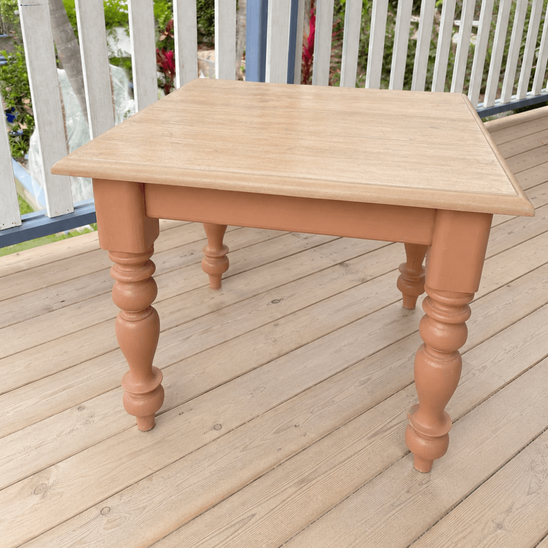 Wooden table with turned legs painted colour Folklore on a wooden deck