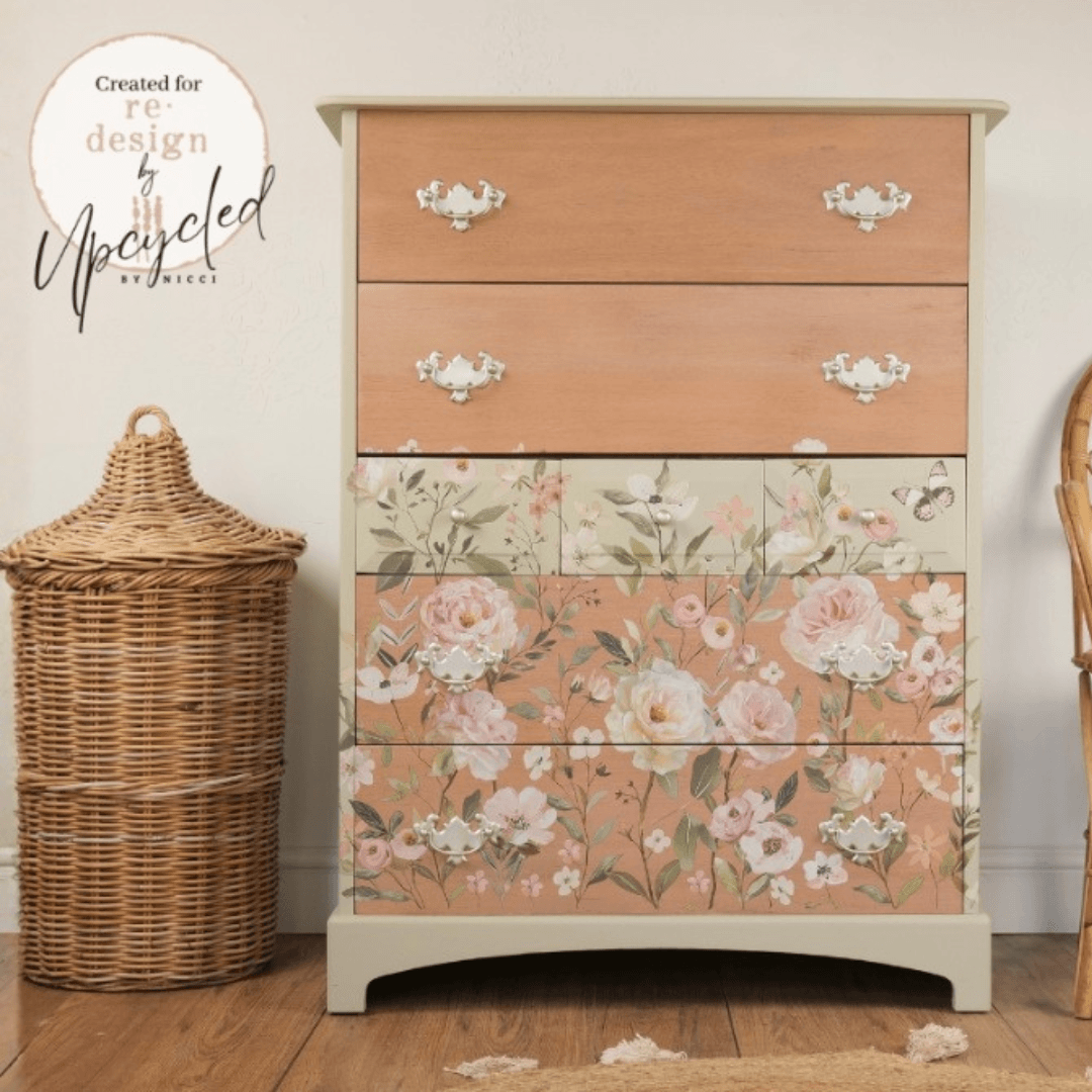 A vintage-style five-drawer chest of drawers with a light beige frame, featuring three solid light wood drawers on top and two floral-patterned drawers below in dusty pink and beige tones. The drawers have ornate silver metal pulls.